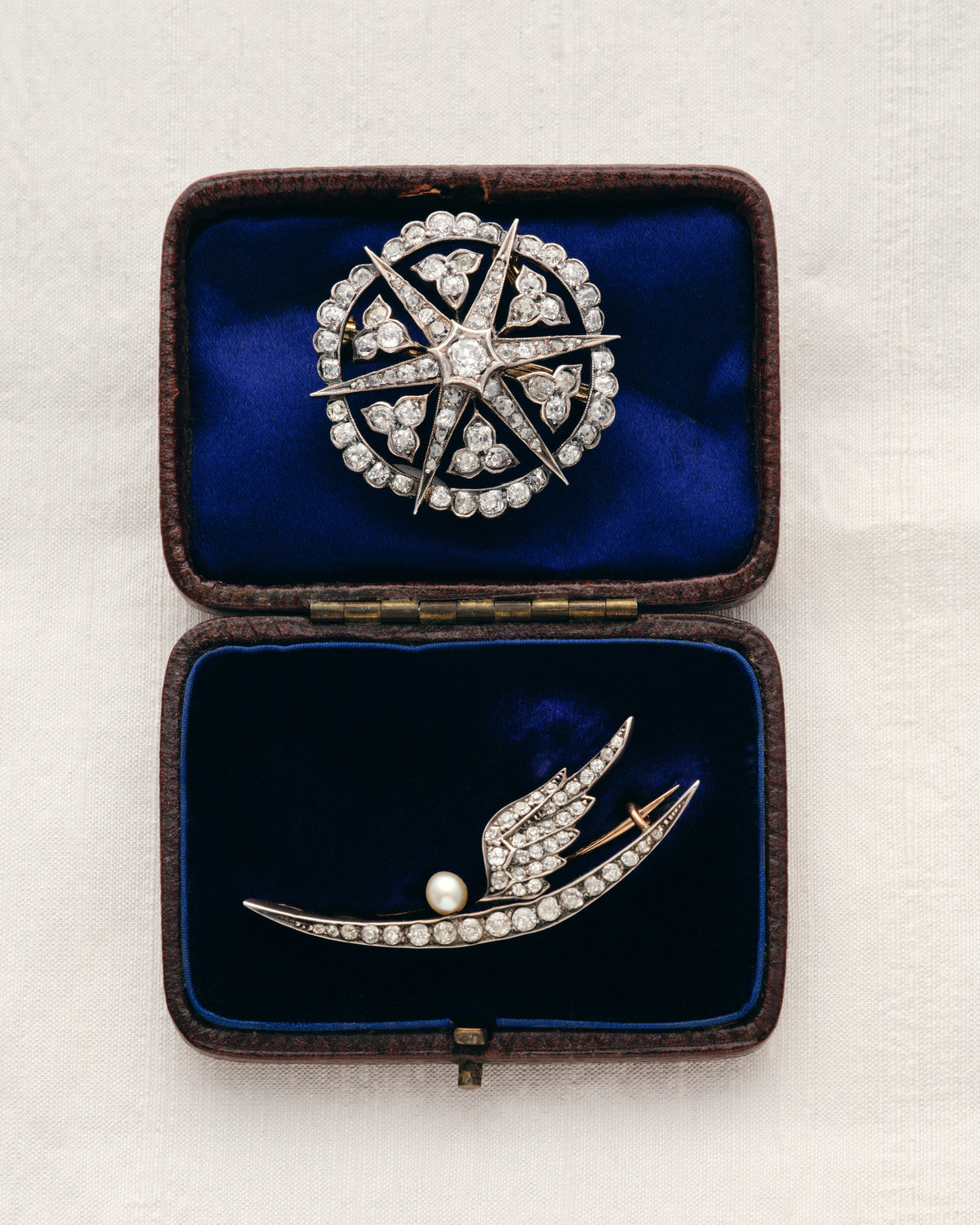 Victorian diamond star and swallow brooches in an antique box