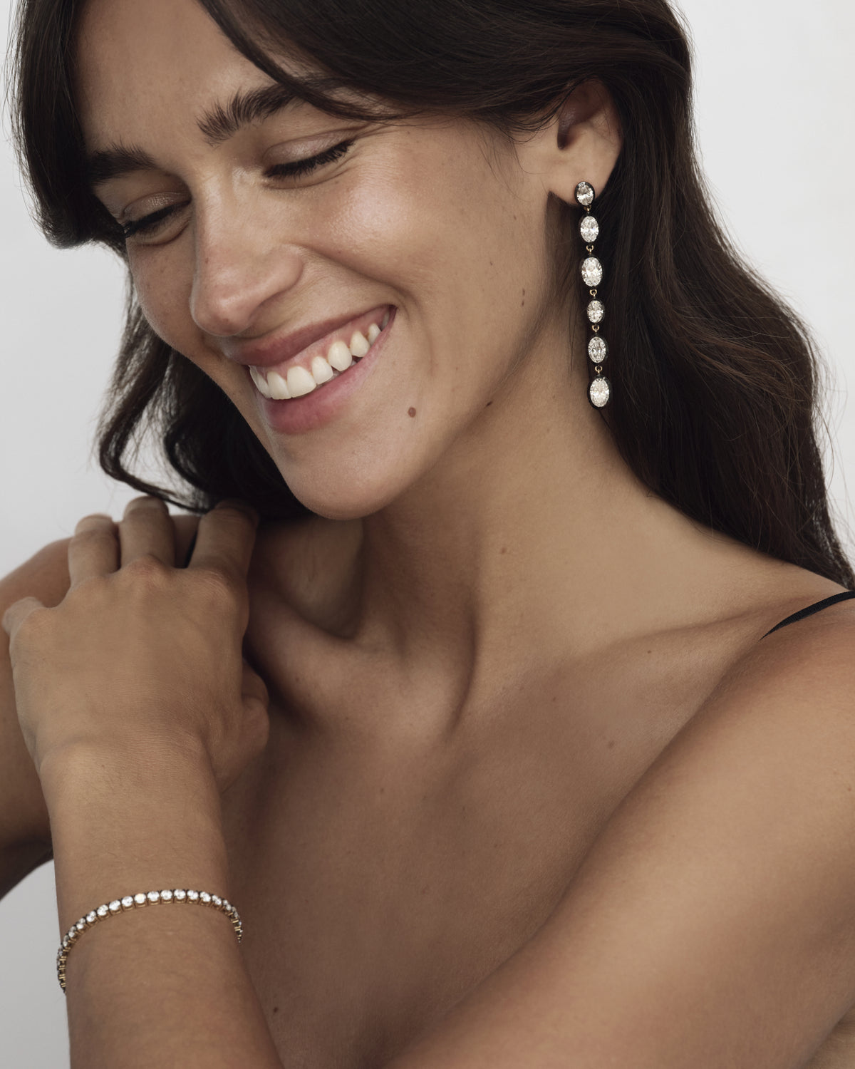 Model wearing long diamond drop earrings