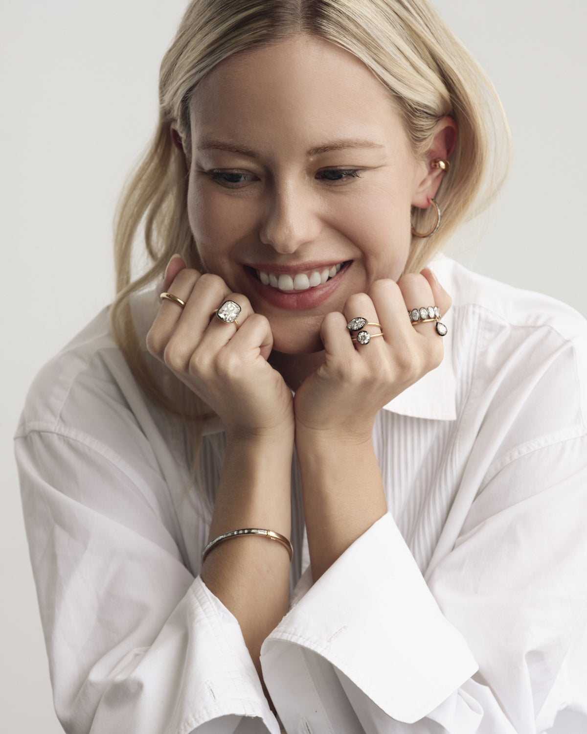 Model in a white shirt wearing rings and bracelets