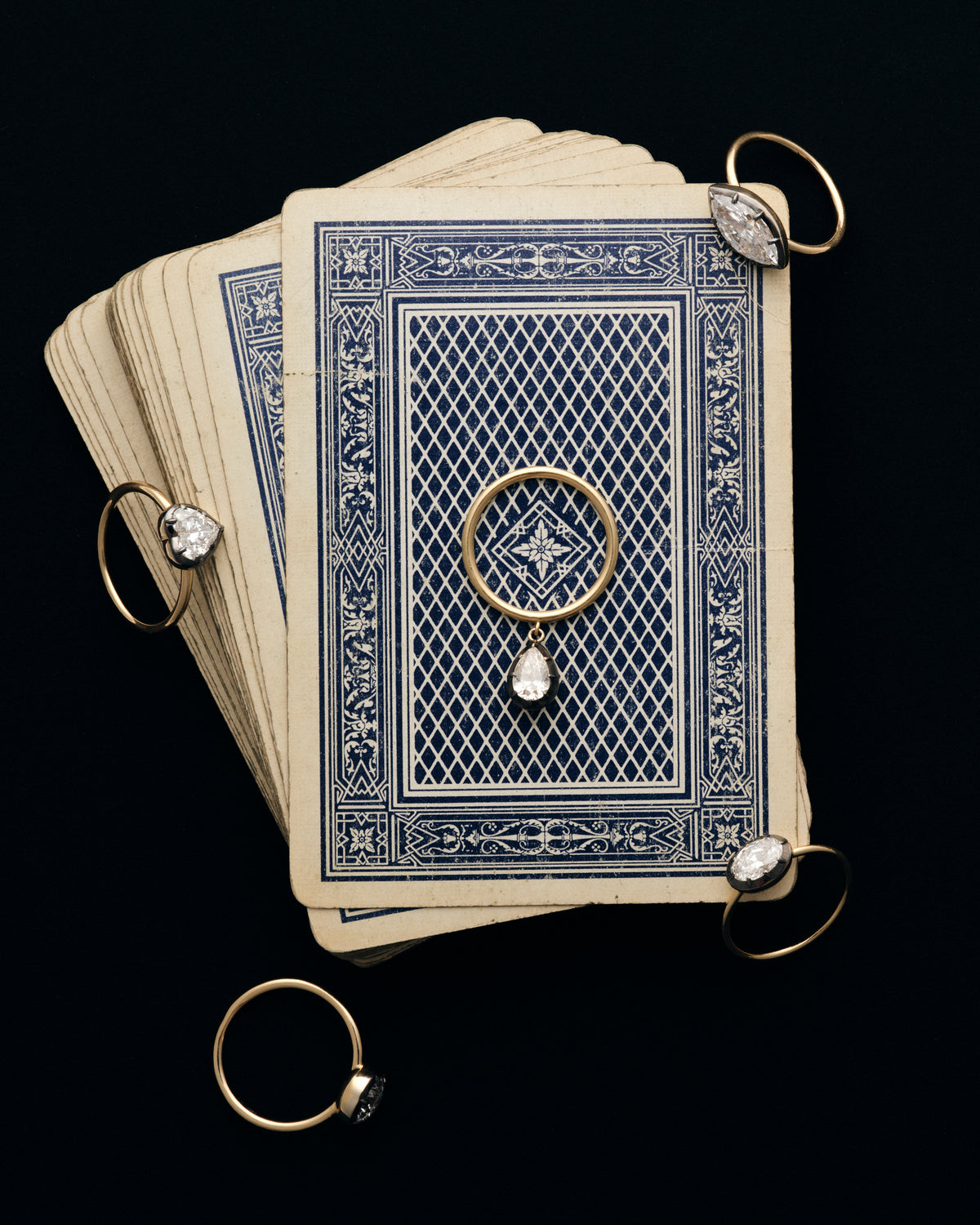Lab-grown diamond rings arranged on antique playing cards